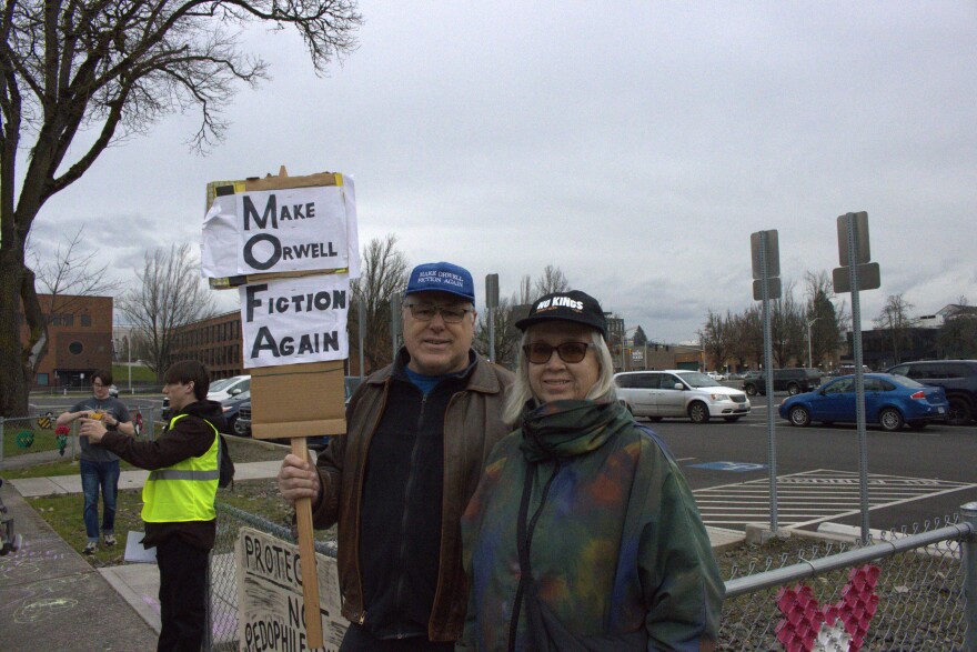 John Brobst and Anne Ryder joined the protest wearing hats saying "Make Orwell Fiction Again" and "No Kings" on Feb. 28, 2026.
