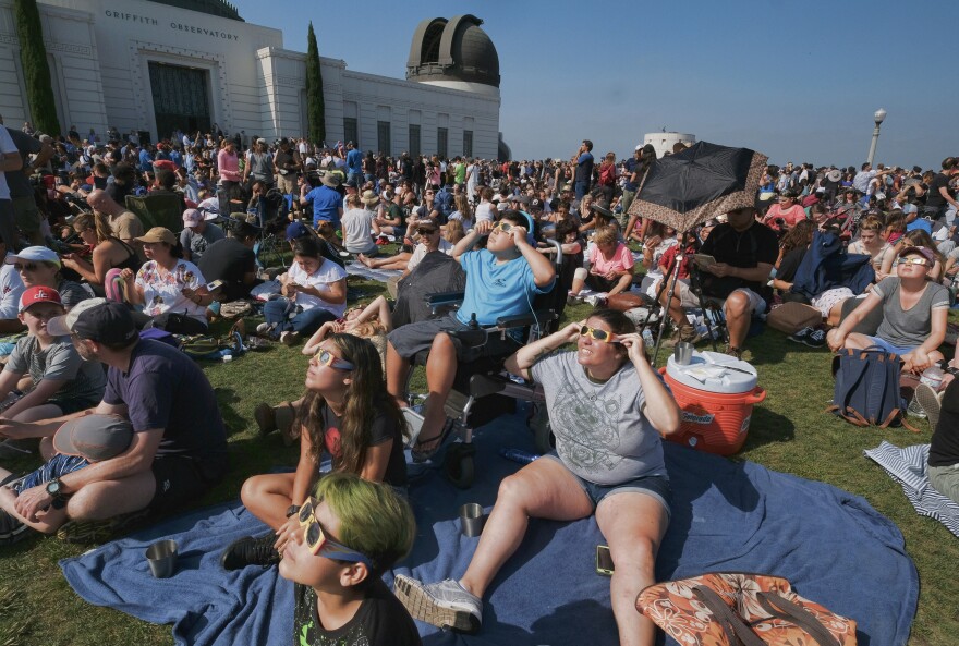 The Tinoco family from Cyprus, Calif., gather to watch the partial eclipse at the Griffith Observatory in Los Angeles on Monday, Aug. 21, 2017. (AP Photo/Richard Vogel)