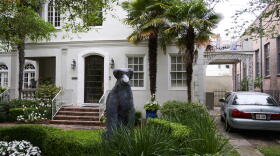 A dog statue wears a mask at a home on St Charles Avenue in New Orleans, Louisiana. April 7, 2020.