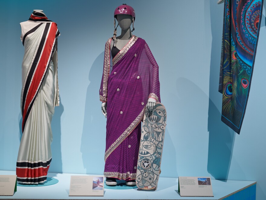 The purple sari in the museum show belongs to Oorbie Roy, a Canadian Indian, who goes by Aunty Skates on social media. She occasionally wears a sari while skateboarding. "She's embracing this fluidity of the sari," says Tiya Dahyabhai, assistant curator of the exhibit. "And actually, you can see around the back of the sari, there's some holes in this area where she's maybe tumbled."