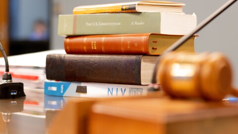 A stack of books, including three Bibles, sat on the table beside State Superintendent Ryan Walters at the May 2024 State Board of Education meeting.