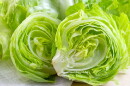 Fresh green iceberg lettuce salad leaves cut on light background on the table in the kitchen