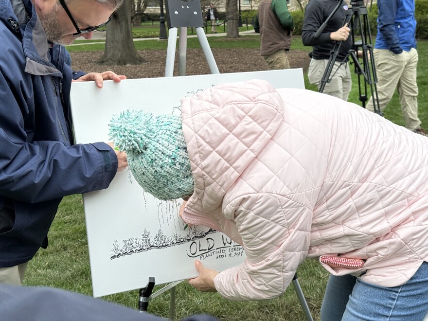 Attendee signing their name on the Old Willow drawing.