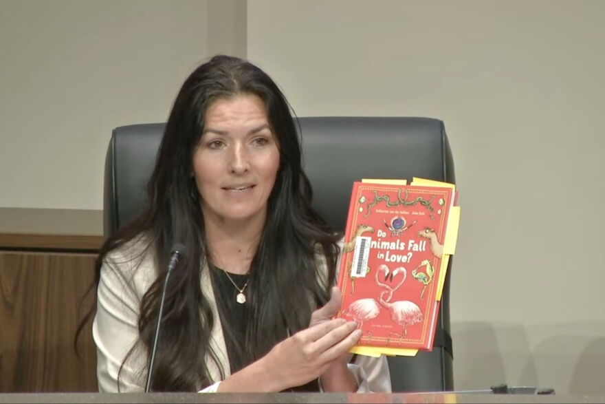 Orange County School Board member Alicia Farrant holds up Do Animals Fall in Love? during a January school board meeting, where the sexual connotation of the book was discussed. The board voted 6-2 to keep the book on school shelves.