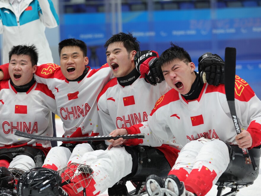 Members of Team China celebrate their win over South Korea during the para ice hockey bronze medal game on day eight of the Beijing 2022 Winter Paralympic.