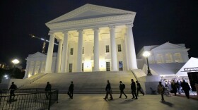 House of Delegates members walk past the south portico at the Virginia State Capitol in Richmond, Va., Wednesday, April 22, 2020.