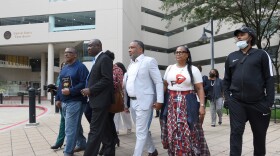 FILE - Attorney Ben Crump, second from left, walks with Ron Lacks, left, Alfred Lacks Carter, third from left, both grandsons of Henrietta Lacks, and other descendants of Lacks, outside the federal courthouse in Baltimore, Oct. 4, 2021. (AP Photo/Steve Ruark, File)
