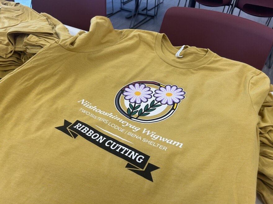 T-shirts bearing the name of the Niishooshimeyag Wigwam (Two Sisters Lodge) Bena shelter await visitors at the building's ribbon cutting event in Bena on Aug. 26, 2026.