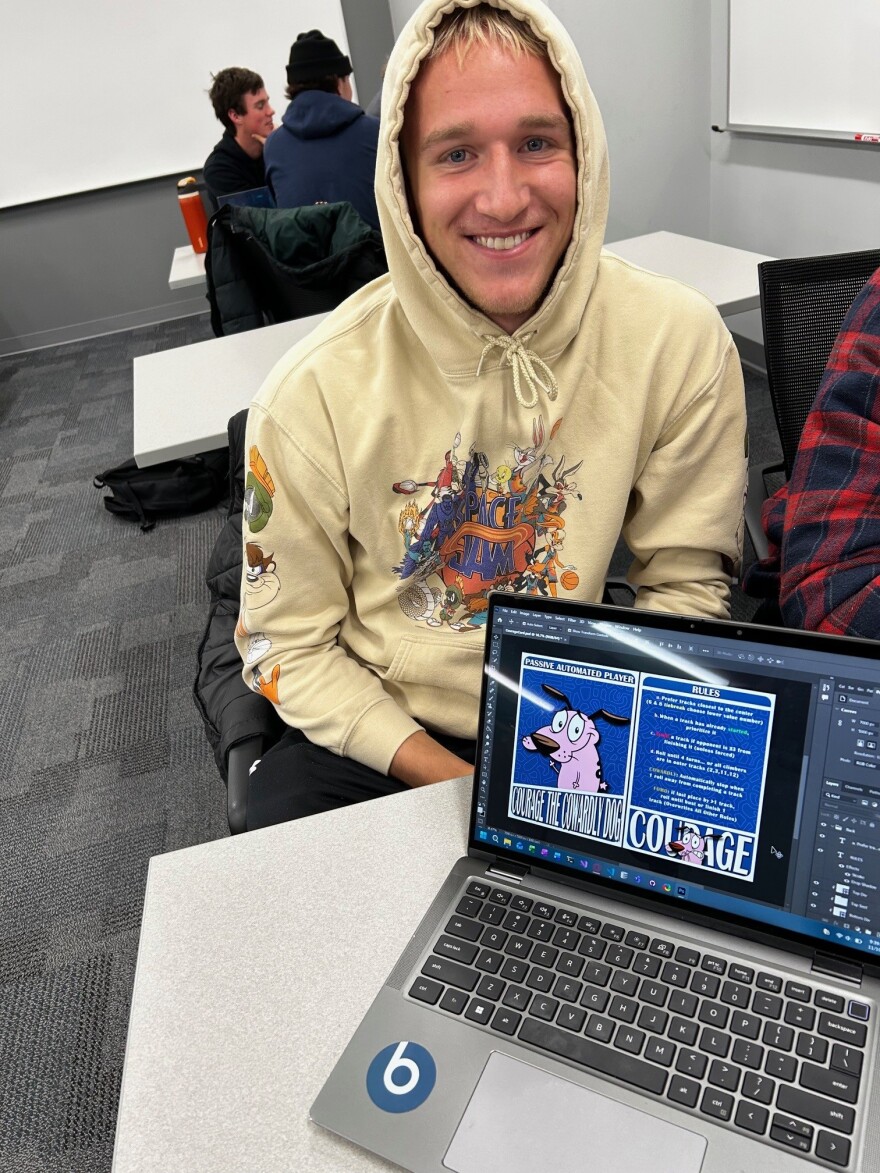 Student with laptop displaying a character chard design featuring Courage the Cowardly Dog