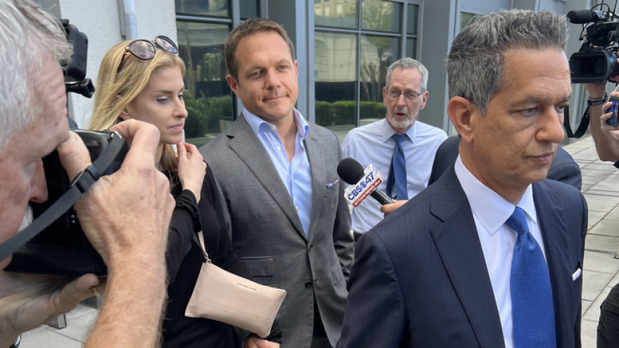 Former JEA CEO Aaron Zahn, back, walks out of the federal courthouse with his wife and attorney Eduardo A. Suarez.