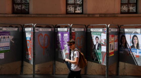 A teenager walks by election posters ahead of the first round of the upcoming legislative elections in Paris on June 9, 2017. (Christophe Archambault/AFP/Getty Images)