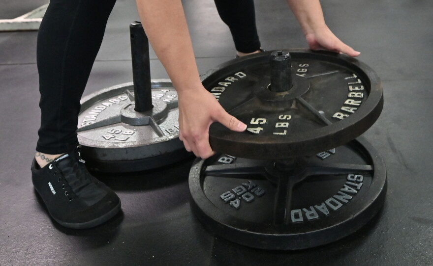 Teresa Troiani adds weight to a special bar to practice lifting the Dinnie Stones at Rocky Boxing Club in Berwick.