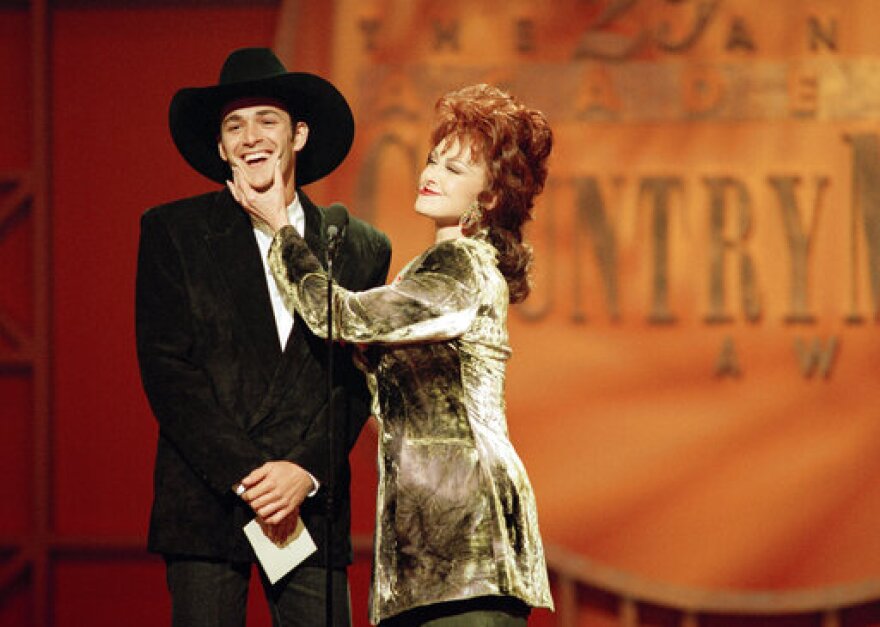  In this May 3, 1994, photo, Naomi Judd pinches the cheeks of Luke Perry after asking him about the title of his new movie, "8 Seconds," during the 29th Academy of Country Music Awards in Universal City, Calif.