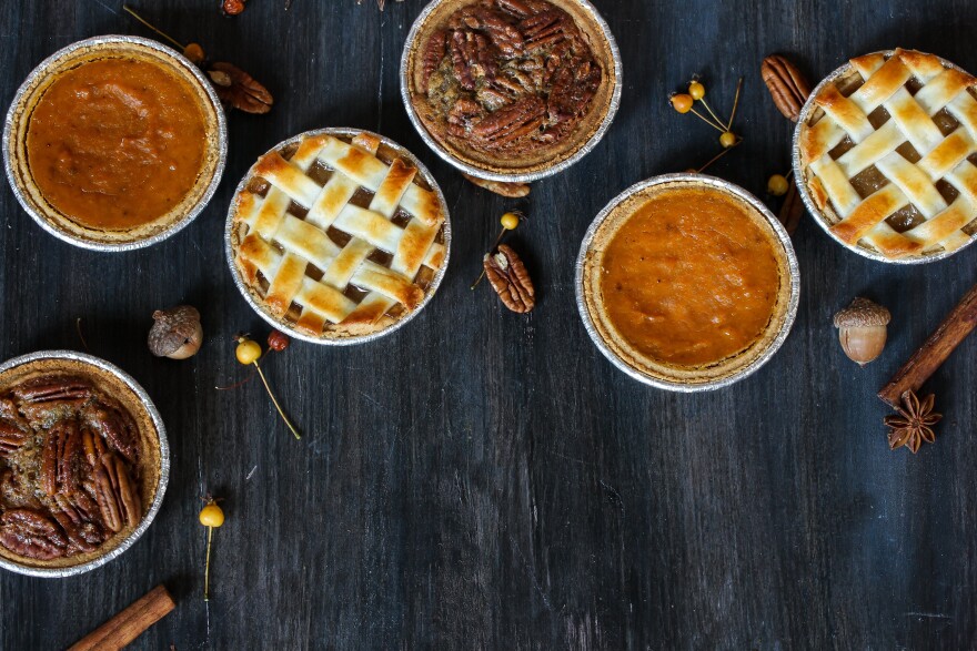 Overhead view of three mini pies - apple pie pumpkin pie and pecan pie / Thanksgiving Desserts