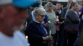 A woman holds a candle vigil honoring the victims of a blast at an explosives plant, Accurate Energetic Systems, Sunday, Oct. 12, 2025, in Waverly, Tenn. (AP Photo/George Walker IV)