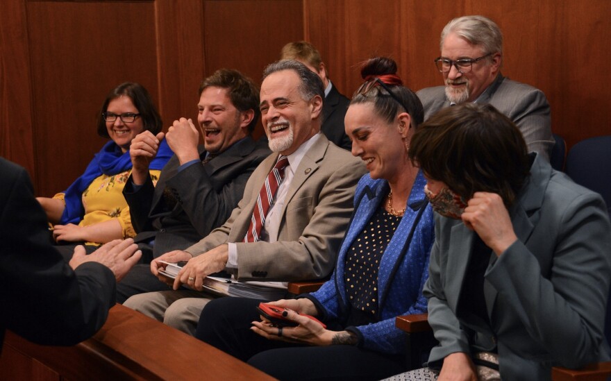 a group of people smiling and laughing in a meeting room