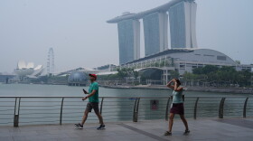 People exercise along the Marina Bay waterfront promenade as the Marina Bay Sands resort is shrouded in transboundary haze from fires in Indonesia, pushing the city’s air quality back into the unhealthy range, Monday, Sept. 14, 2026 in Singapore.