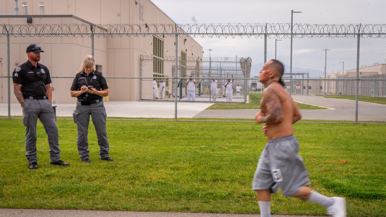 An inmate jogs past guards and security fencing during the Fit From Within half-marathon inside the Utah State Correctional Facility in Salt Lake City, June 18, 2025.