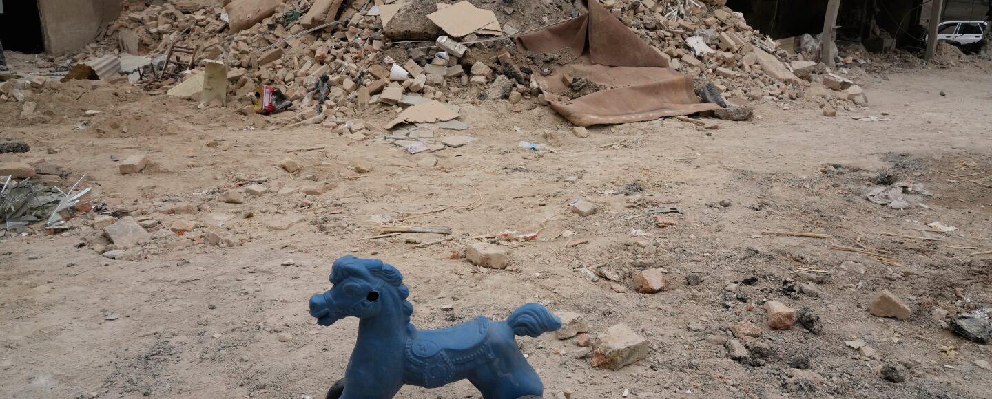A toy remains on the ground next to a residential building damaged when a nearby police station was hit Friday in a U.S.-Israeli strike in Tehran, Iran, Sunday, March 15, 2026.