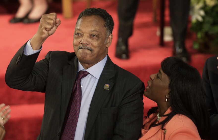 FILE - Rev. Jesse Jackson gestures to a friend in the balcony at the 16th Street Baptist Church in Birmingham, Ala., Sept. 15, 2013. The church held a ceremony honoring the memory of the four young girls who were killed by a bomb placed outside the church 50 years ago by members of the Ku Klux Klan. At right is U.S. Rep. Terri Sewell, D-Ala.