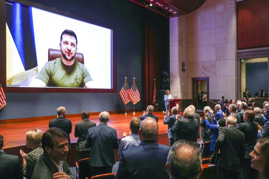 Members of Congress give Ukraine President Volodymyr Zelensky a standing ovation before he speaks in a virtual address to Congress in the U.S. Capitol Visitors Center Congressional Auditorium in Washington, Wednesday, March 16, 2022. (Sarahbeth Maney/The New York Times via AP, Pool)