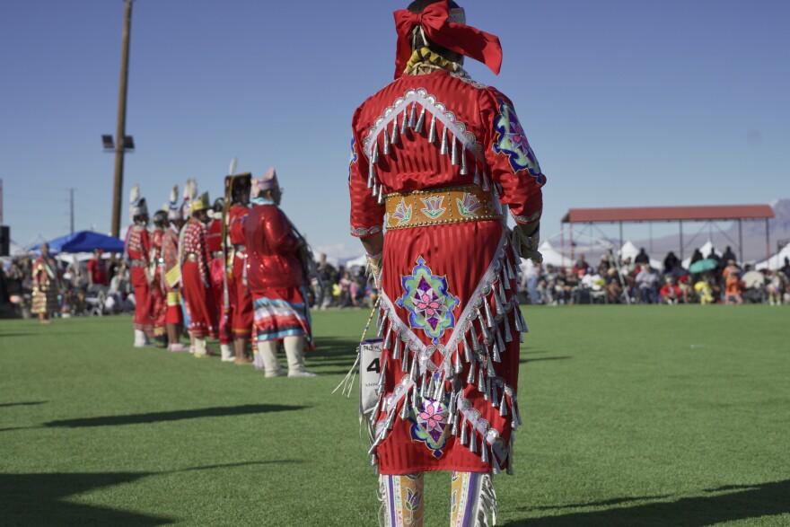 A woman dancer stands on the cirlce awaiting to participate in the red dress dance to commemorate the Missing and Murdered Relatives during the Snow Mountain Powwow, on Saturday, Oct. 11, 2025.