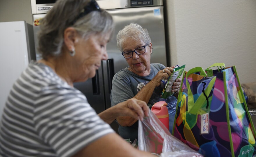 Lori Schenone and Kathy Church volunteer at the food pantry serving the Royal Palm Village community in Haines City, Florida. They deliver groceries to seniors who are struggling to pay rising lot rent and other living expenses.