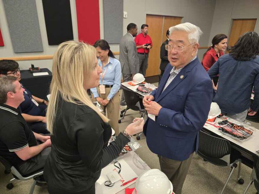 Bexar County Judge Peter Sakai speaks to Deborah Carter, the county's director of economic development before the bus tour of the axle plant on March 2, 2026