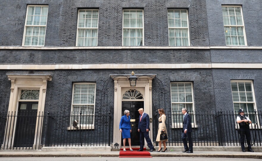 May, Trump, first lady Melania Trump and Philip May arrive at 10 Downing Street, the prime minister's residence, where a red carpet was rolled out to greet them. On a windowsill to the left, Chief Mouser Larry the Cat keeps watch.