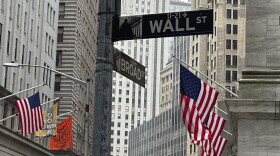American flags hang from the front the New York Stock Exchange, right, on Thursday, April 11, 2024 in New York. Shares in Europe and Asia are mostly lower after U.S. stocks fell following another release of hotter than expected inflation data. (AP Photo/Peter Morgan)