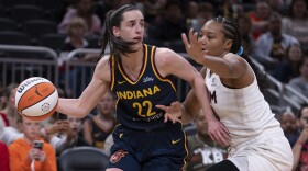 Indiana Fever's Caitlin Clark (22) looks to pass the ball as Atlanta Dream's Naz Hillmon defends during the second half of a WNBA preseason basketball game Thursday, May 9, 2024, in Indianapolis.