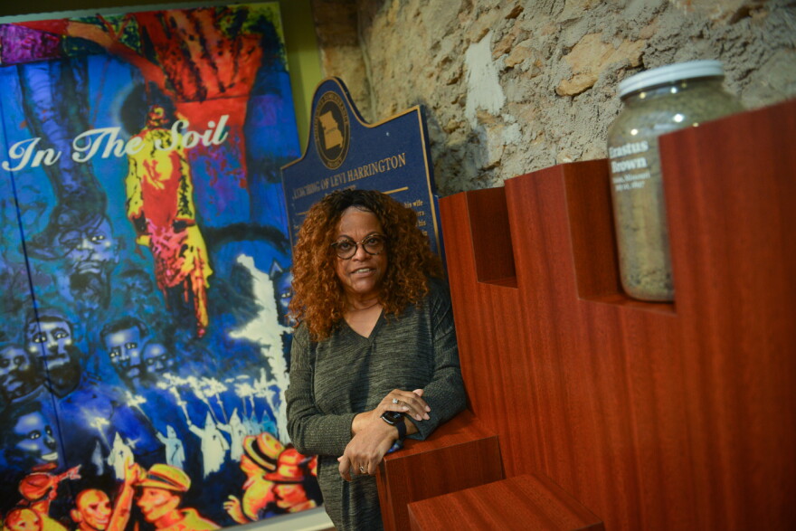 Carmaletta Williams, the executive director of the Black Archives of Mid-America  stands next to the empty slot where the soil from Levi Harrington's lynching will be stored in a glass jar following a ceremony Saturday.