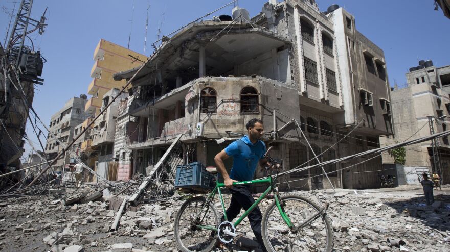 A Palestinian man pushes his bicycle amid debris following an Israeli military strike in Gaza City on Wednesday. While Israel and Hamas have clashed repeatedly in Gaza, the West Bank has been comparatively calm in recent years.