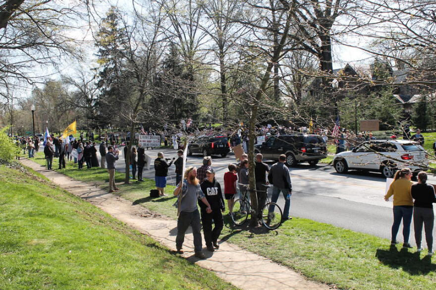 Protesters lined the street in front of the governor’s mansion waving American flags and holding signs as supporters honked in passing. (Lauren Chapman/IPB News)