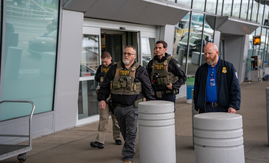 Federal Immigration and Customs Enforcement agents walk outside the terminal at Cleveland Hopkins International Airport.