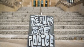 Demonstrators at Kansas City Police Headquarters used a large plywood sign to express their overriding sentiment during a protest Wednesday evening.