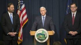 Kent Abernathy, left, the new commissioner of the Indiana the Bureau of Motor Vehicles, and former commssioner Don Snemis, right, listen as Gov, Mike Pence announces he is launching an internal audit of the Bureau of Motor Vehicles and is seeking legislation to streamline the agency's fee structures amid revelations it overcharged motorists another $2 million over six years, at the Indiana State House, Indianapolis, Monday, Feb. 2, 2015.
