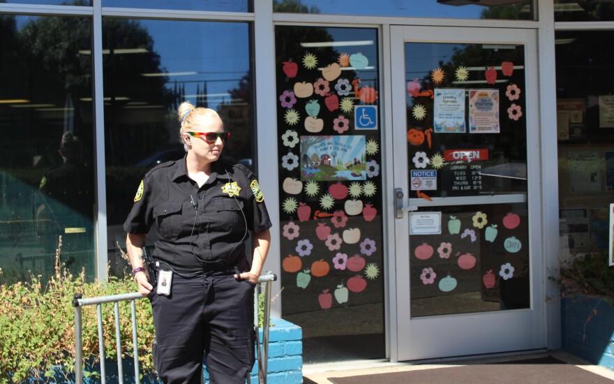 A security guard stands in front of a library in Durham, Calif.