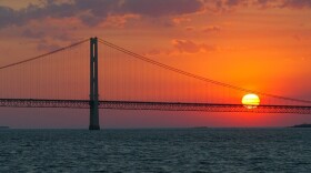 The sun sets over the Mackinac Bridge and the Mackinac Straits as seen from Lake Huron. The bridge is the dividing line between Lake Michigan to the west and Lake Huron to the east. (AP Photo/Al Goldis)