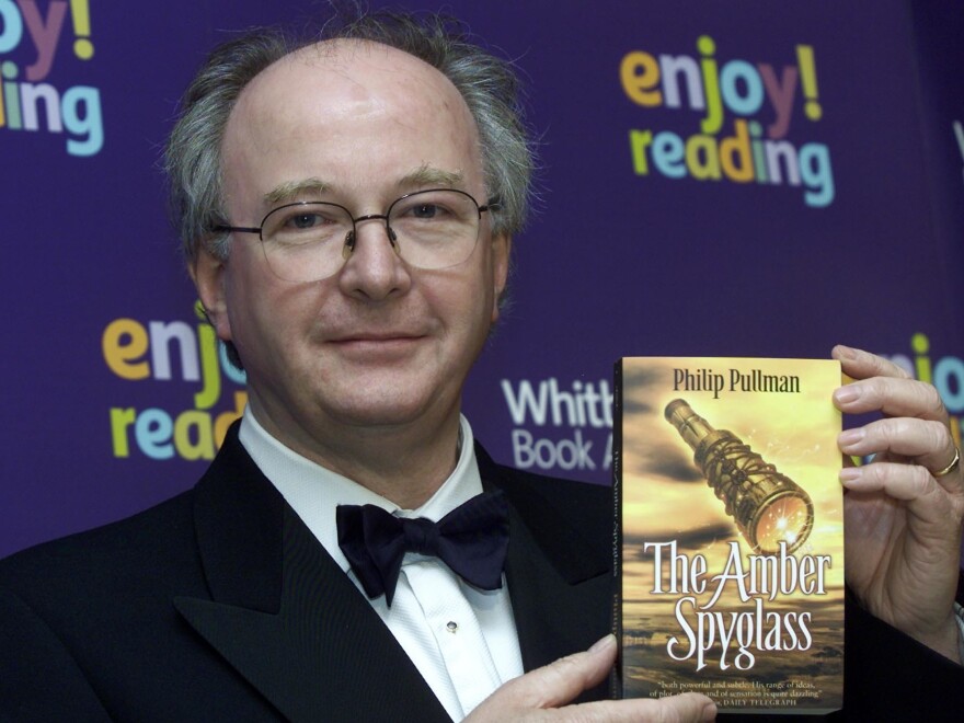 Pullman, author of the <em>His Dark Materials</em> trilogy, holds a copy of its concluding volume, <em>The Amber Spyglass</em>. The first book of a new series will be published in Fall 2017.