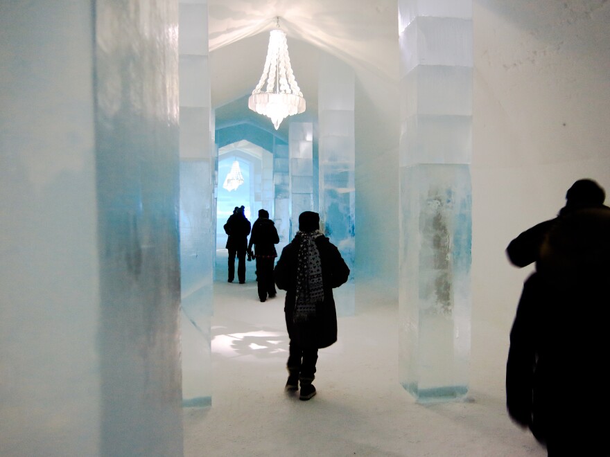 Visitors walk past icy decorations at Icehotel. Artists from around the world compete for the chance to design rooms in the Swedish landmark, and every year the hotel is rebuilt from scratch, with new sculptures.