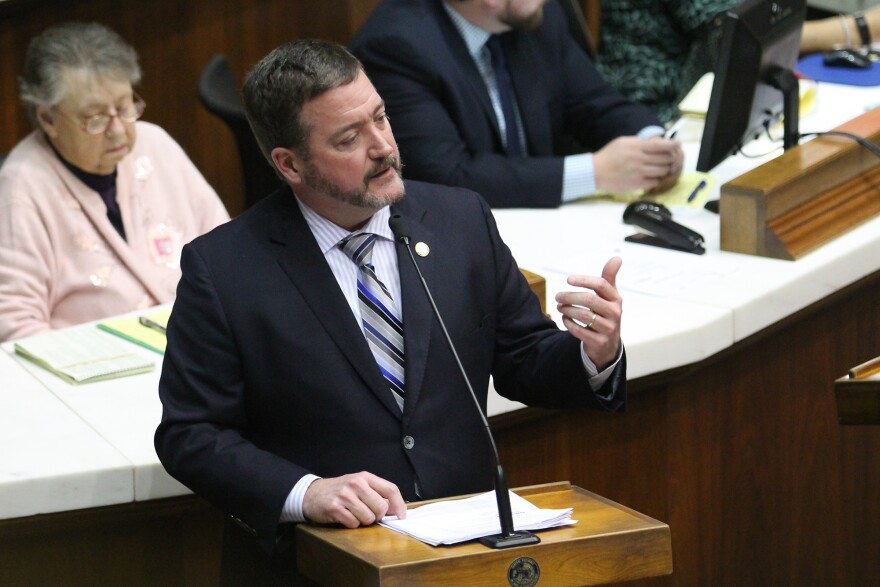 Representative Chuck Goodrich speaks on the House floor. He is a white man with black hair and a full beard.