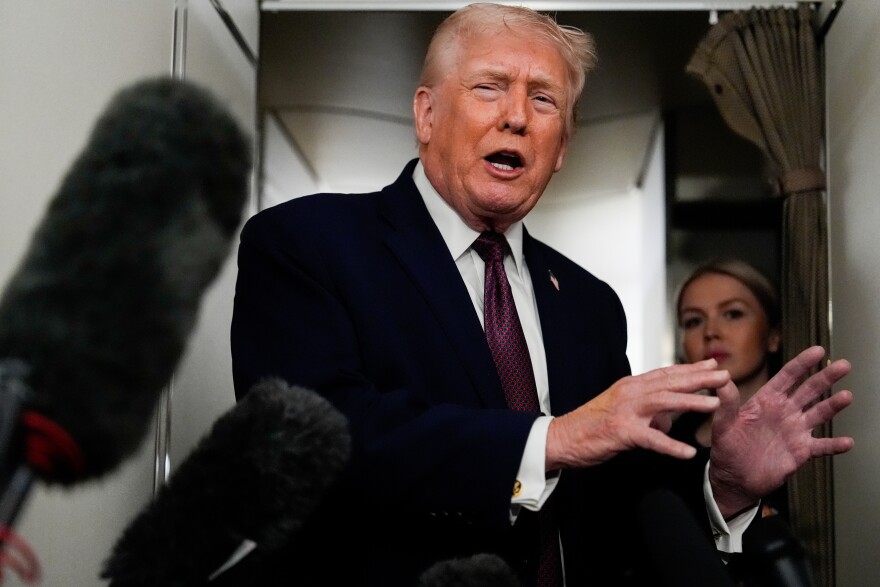 President Donald Trump speaks to reporters while in flight on Air Force One to Joint Base Andrews, Md., Sunday, Jan. 11, 2026. (AP Photo/Julia Demaree Nikhinson)