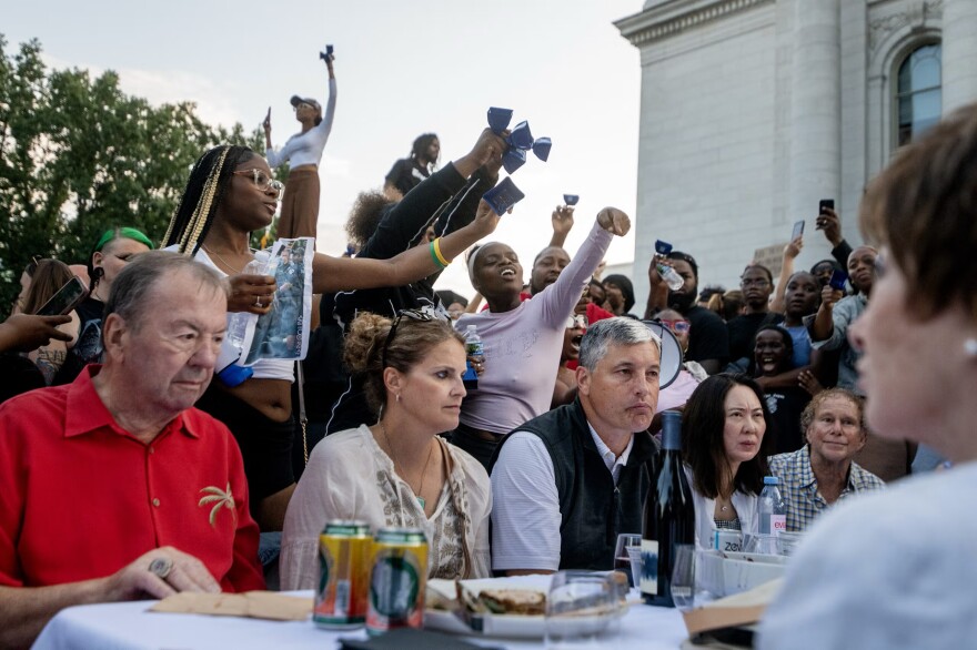 Protesters approach attendees of a Concerts on the Square event in Madison