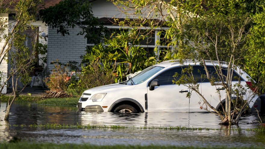 A car sits in high water in front of a home in the aftermath of Hurricane Milton, Thursday, Oct. 10, 2024, in Tampa.
