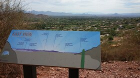 This is a view of the East Valley and beyond. There are several mountains in the background including Superstition, Four Peaks and McDowell Peak. The sign helps hikers identify where the mountains are located.