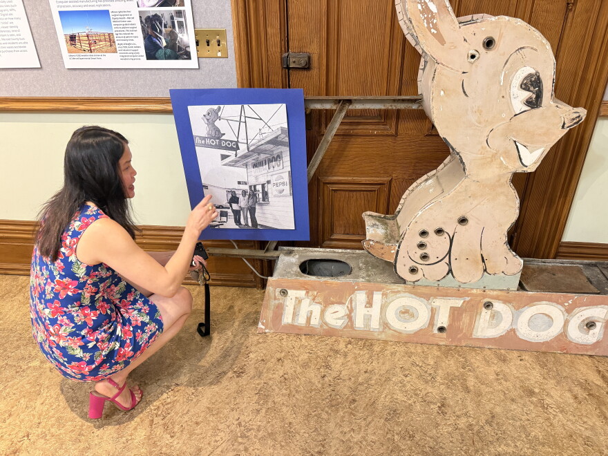Sarah Lim talks about a photo of a hot dog stand with a sign she received for a display.