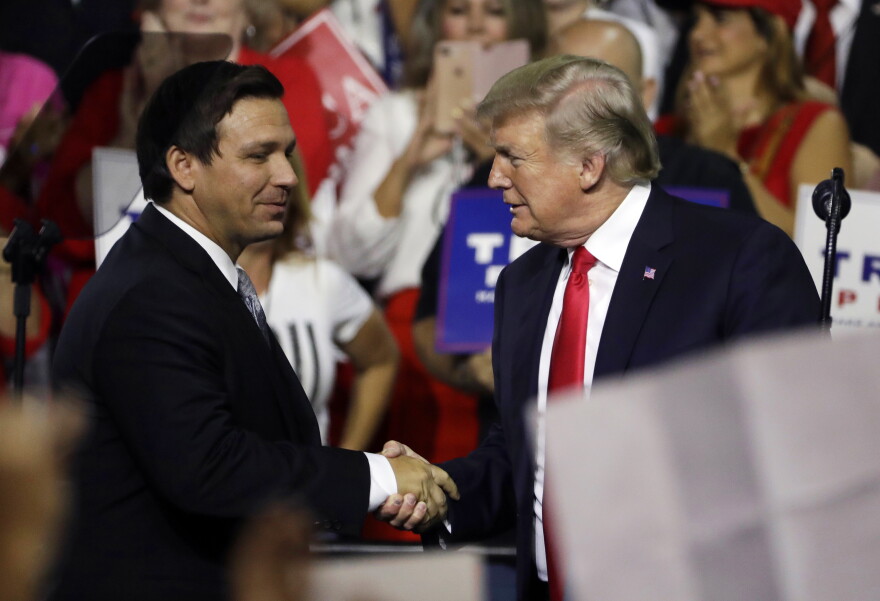  In this July 31, 2018, file photo, President Donald Trump (right) shakes hands with Florida Republican gubernatorial candidate Ron DeSantis during a rally in Tampa, Fla. 