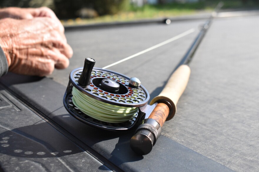 A fly fishing rod as someone ties on a fly.