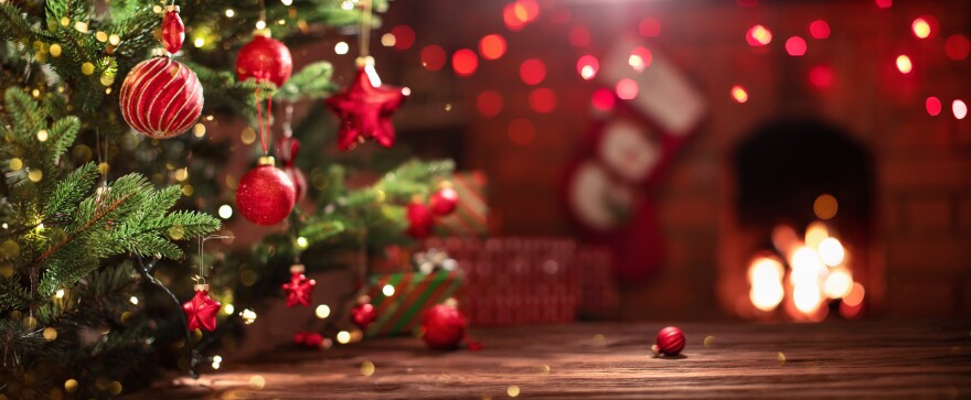 This stock photo shows a decorated Christmas tree near a fireplace.
